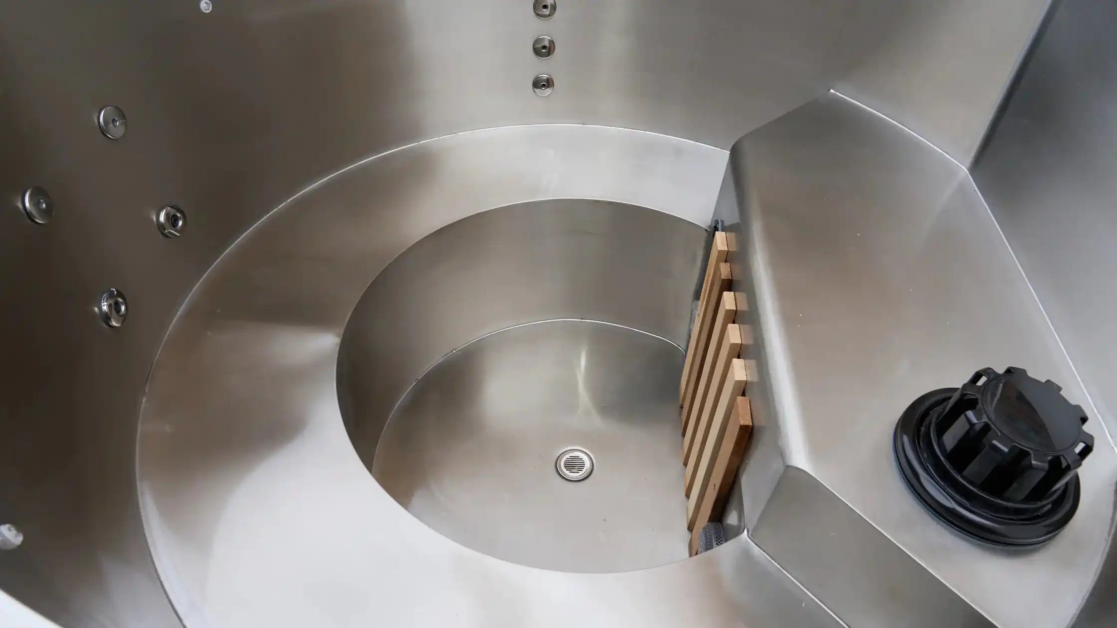 Close-up of a metallic spiral design with a wooden block and black component.