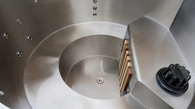 Close-up of a metallic spiral design with a wooden block and black component.