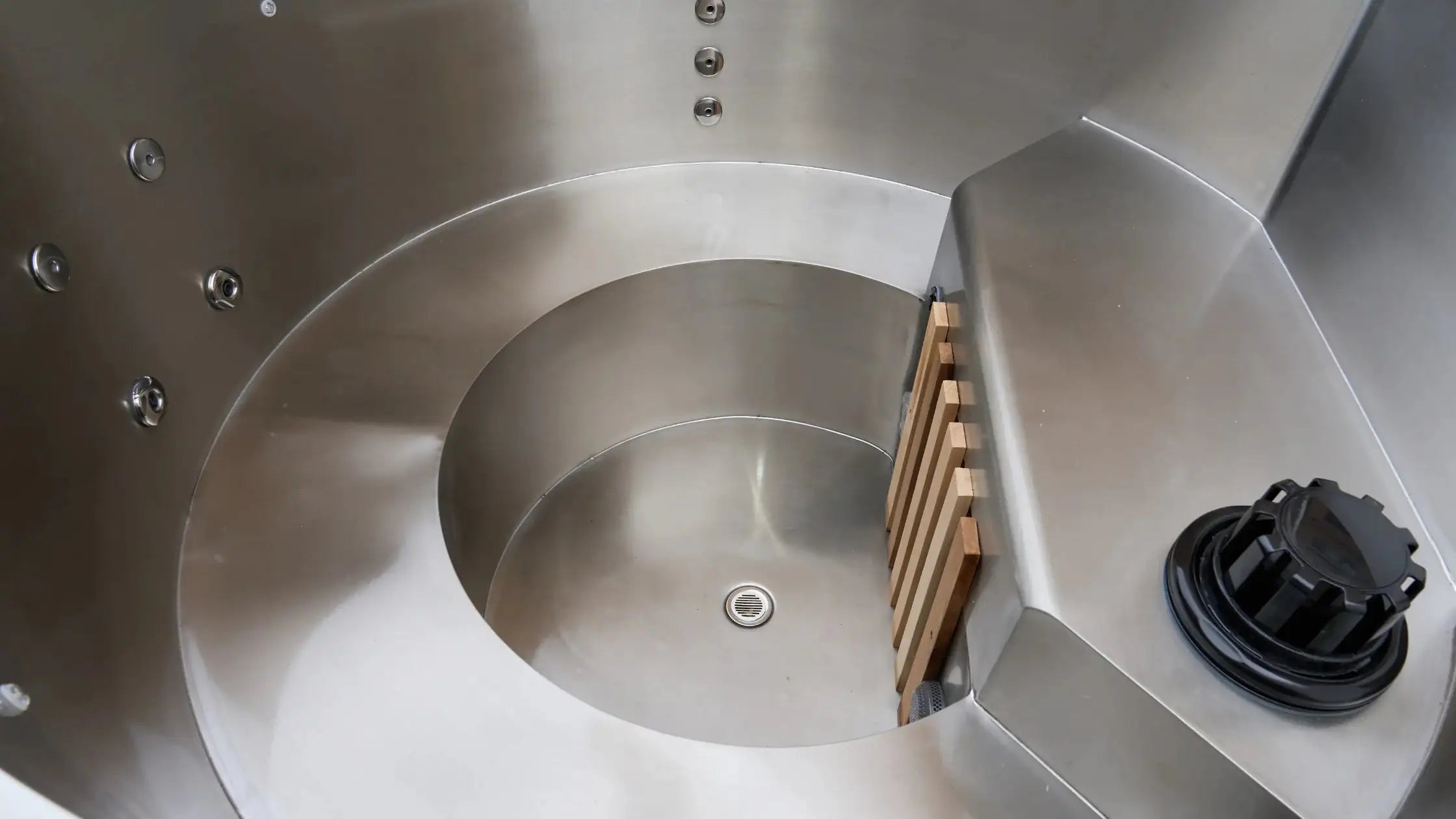 Close-up of a metallic spiral design with a wooden block and black component. Condor  Andes Hot Tubs